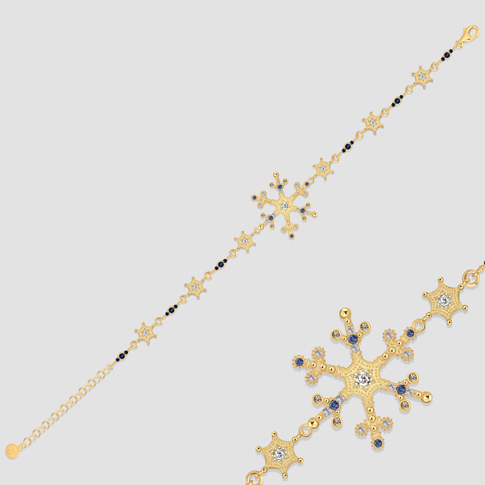 Snowflake Ice X Armkette Gold aus 925 Sterling Silber mit Zirkonia-Mix, Detailansicht auf grauem Hintergrund.