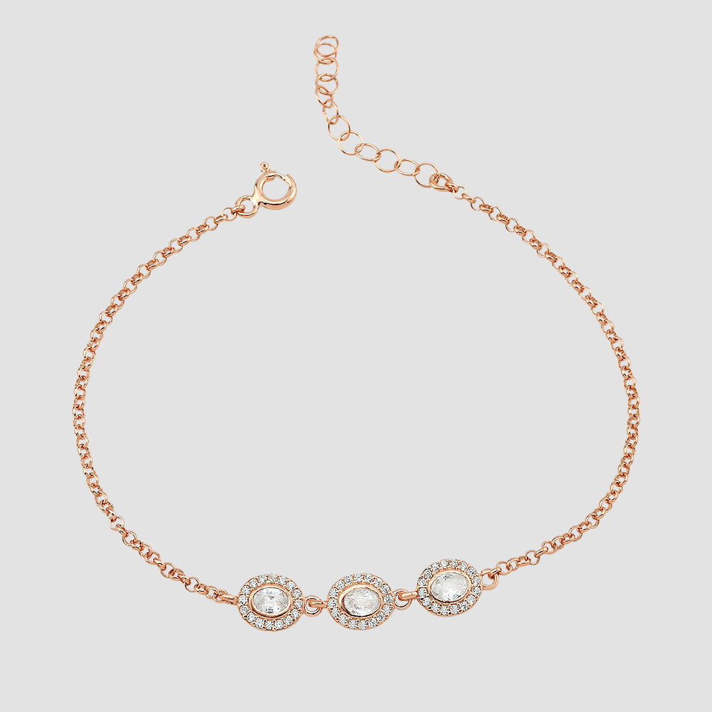 Filigranes Solitaire Kranz Oval Armband in Rosé mit drei Zirkonia auf hellem Hintergrund.