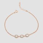 Filigranes Solitaire Kranz Oval Armband in Rosé mit drei Zirkonia auf hellem Hintergrund.
