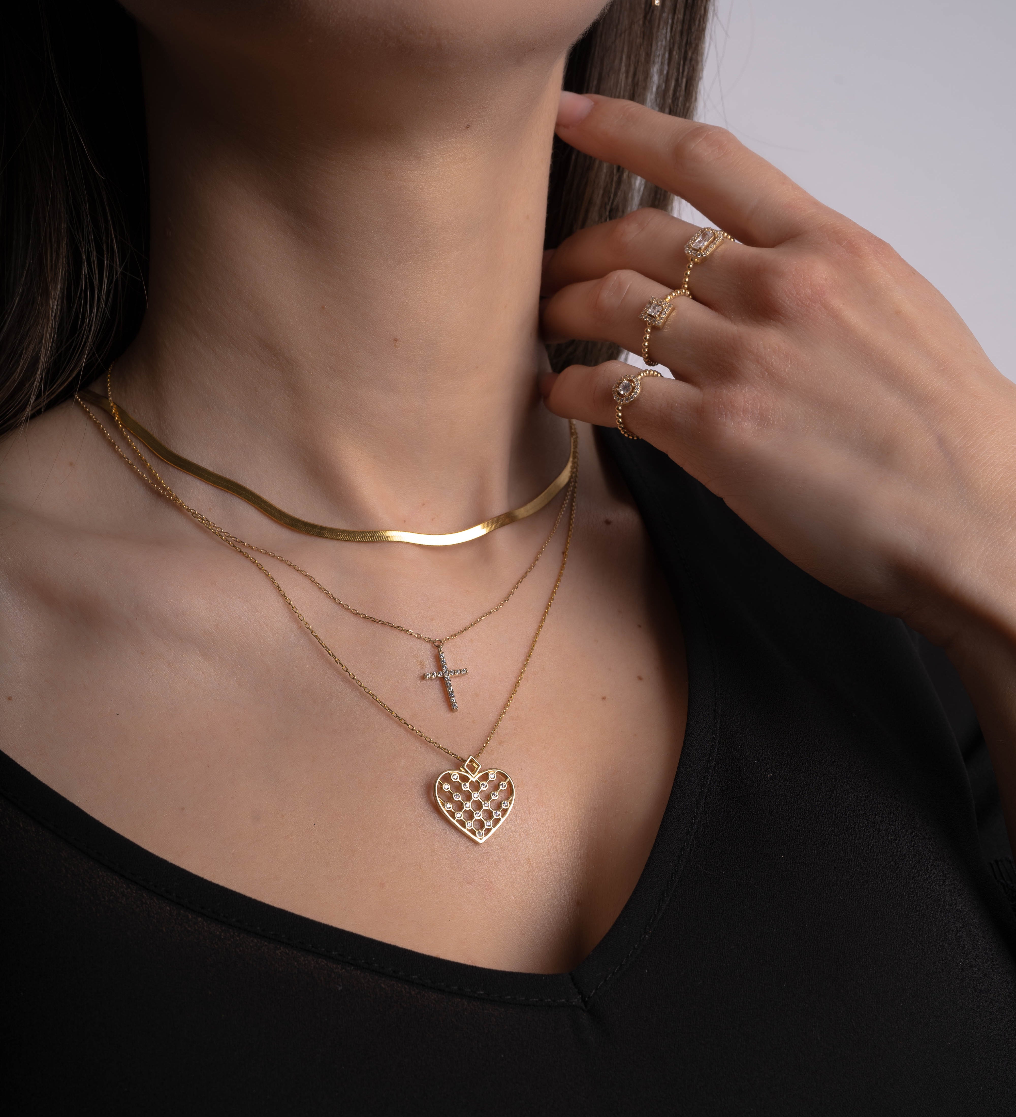Model trägt Unique Heart Gold Halskette mit Zirkonia-Herzanhänger im Layering-Look.