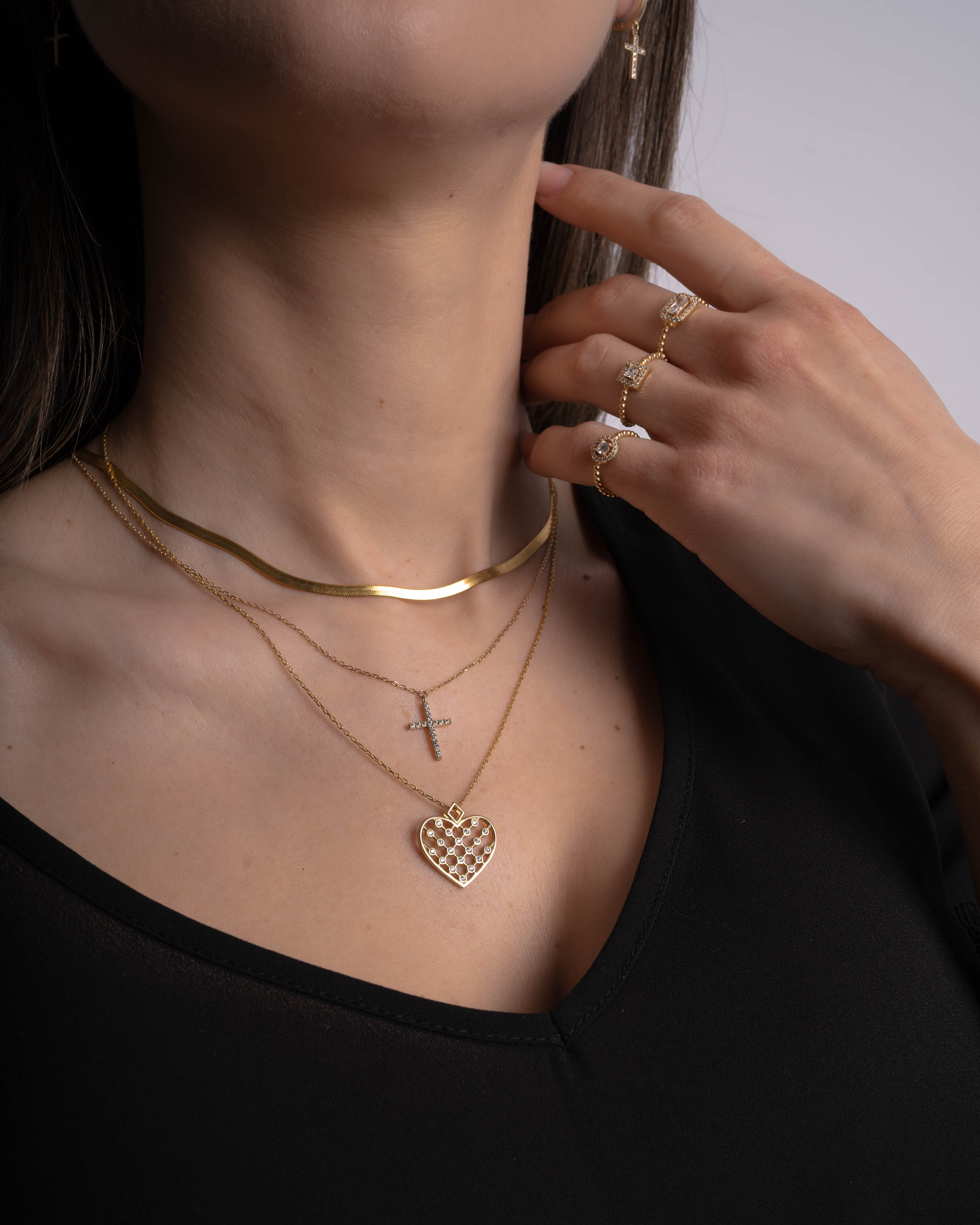 Model trägt Unique Heart Gold Halskette mit Zirkonia-Herzanhänger im Layering-Look.